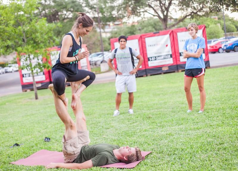 Sarah Pickett and Jean-Pierre Sanchez look on as Clay Ford and Ruthie Ocean participate in Acro Yoga on Tuesday. Junior ruthie Ocean regularly hosts Acro Yoga sessions on Prassel Lawn in which she teaches exotic yoga positions. Photo by Anh-Viet Dinh.