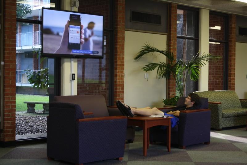Junior Tim Jablonski takes a break from studying to enjoy a show on one of the new HD TVs in the North/South Foyer. Photo by Sarah Cooper.