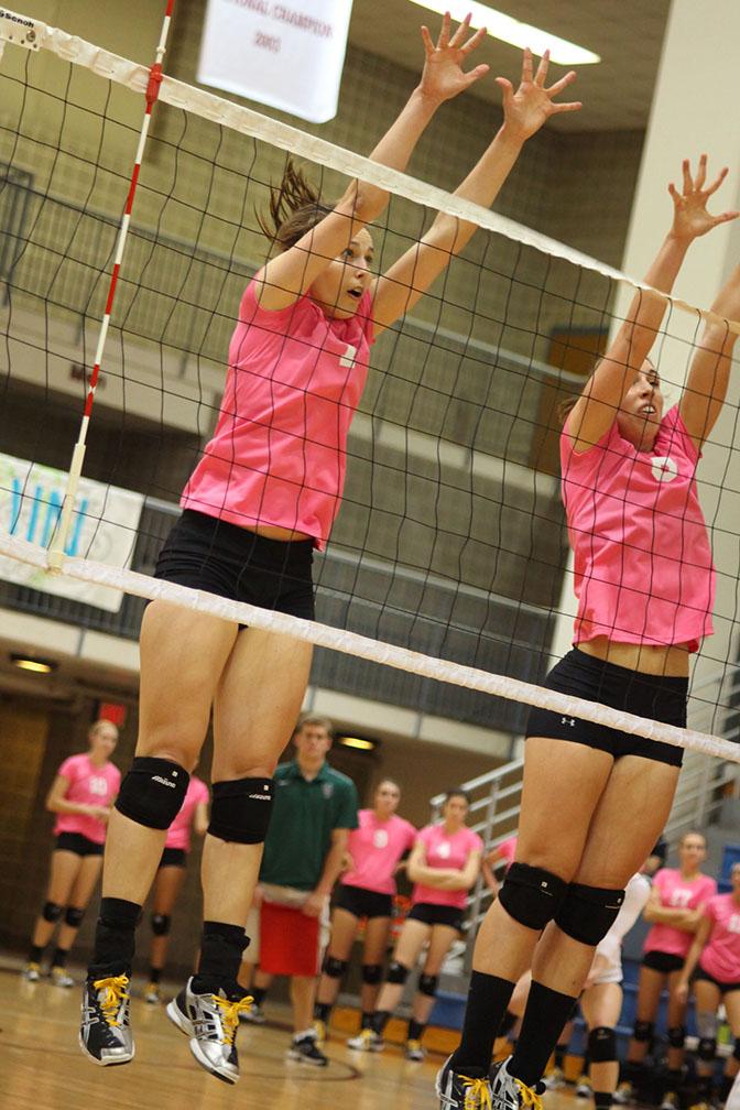 Senior middle blocker Jana Tucker (left) jumps along side junior middle blocker Kelsey Daniel in hopes of blocking the ball during the game against Our Lady of the Lake last Friday. Photo by Anh-Viet Dinh.