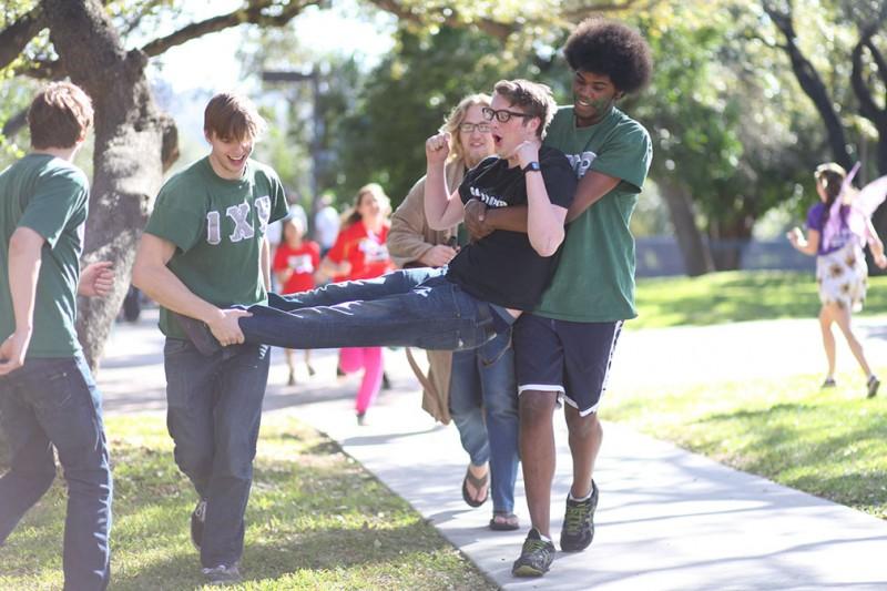 Sophomores and members of Iota Chi Rho Clayton Ford and Darin Feagins carry first-year William Freeman toward Miller Fountain for his honorary dunk in the water, as per Bid Day tradition. Photo by Anh-Viet Dinh.
