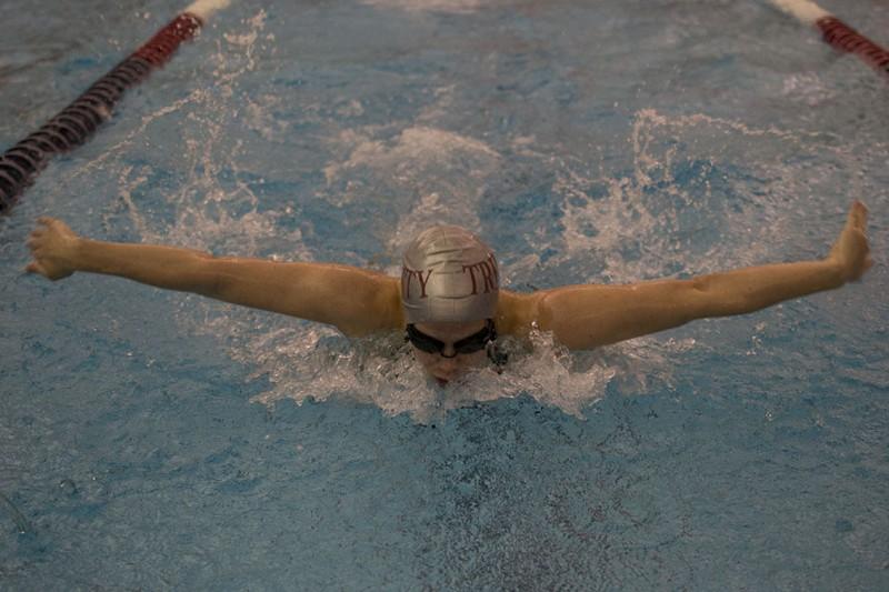 photo courtesy of James Shultz. Senior Mary Price competes in the 100-meter butterfly during the conference meet Feb. 13-16. Price set a school record in this event.