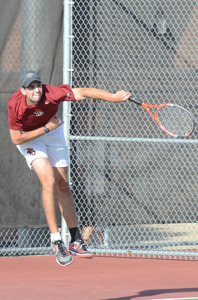 First year Connor Dunn fires the ball at his opponents during a doubles match with John Hopkins University on Wednesday. Photo by Sarah Cooper.