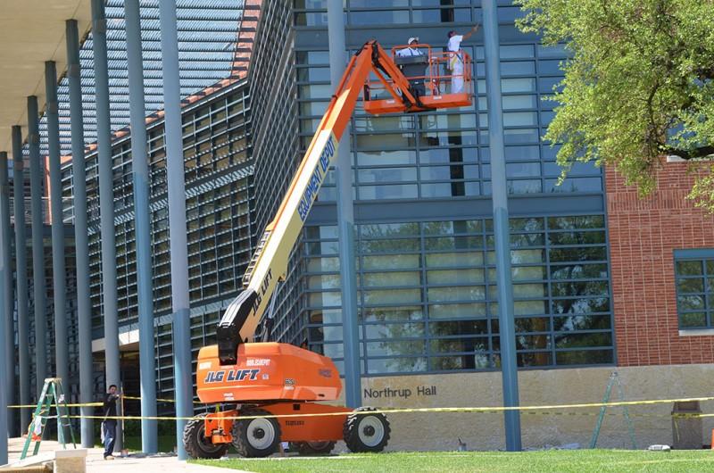 Woders use a crane to paint the columns outside of Northrup Hall as a part of the ongoing spring cleaning that includes painting and window washing.