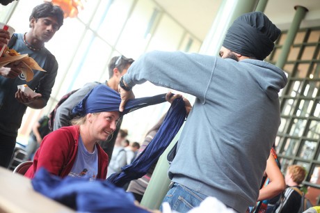 Junior Jasdeep Singh ties turbans on students in Coates University Center as a part of Tie a Turban Day hosted by Sikh Student Association to raise awareness about Sikhs and why turbans are worn.