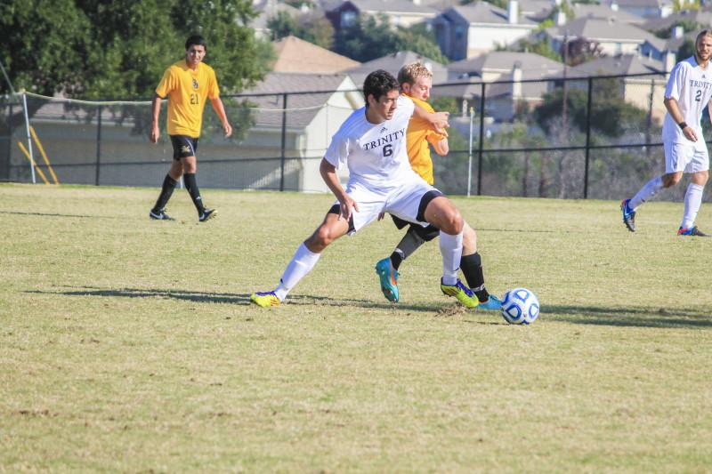 Junior midfielder Simon Uribe battles a defender moments before he scored the winning goal during the SCAC championship game against Southwestern University. Photo by Lydia Duncombe.