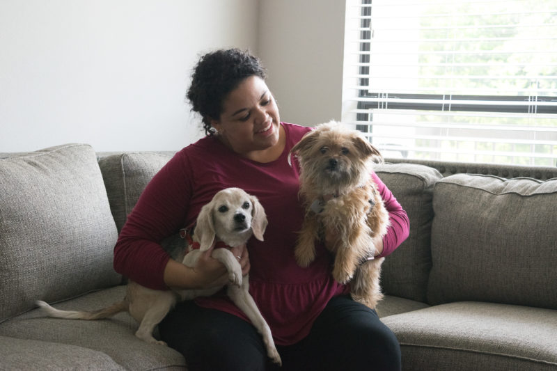 MELISSA FLOWERS poses with her two pet dogs in her City Vista living room. Flowers also shares the apartment with her husband and two young children, who frequently visit the pool and hang out in some of the apartmentâ€™s lounges and game rooms.
photos by Allison Wolff