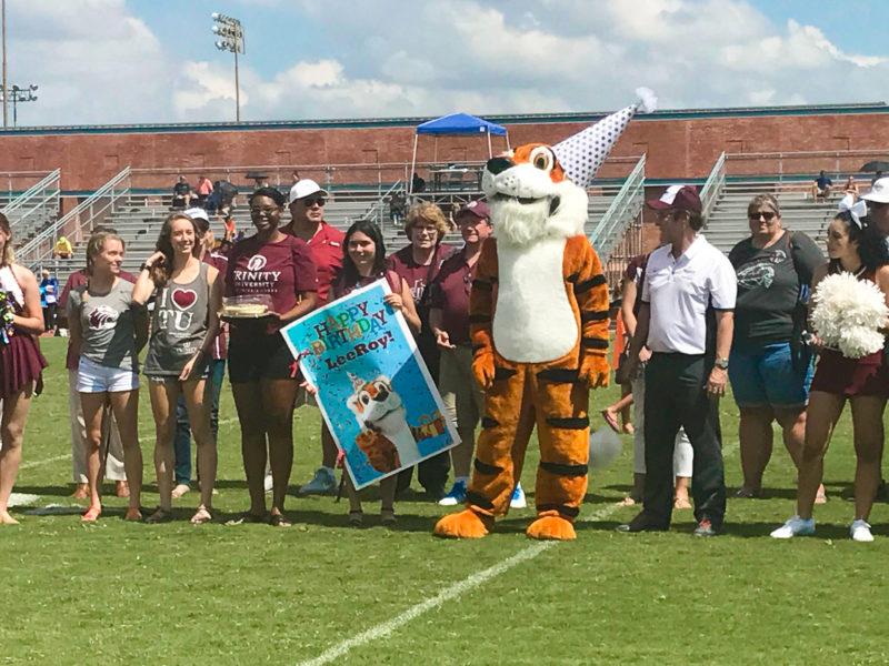 Students present LeeRoy with a large birthday card at the first football game of the season. Photo provided by Tess Coody-Anders