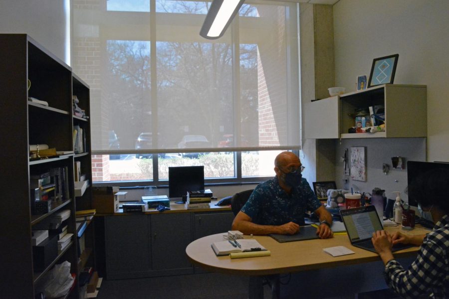 Matthew Hibbs sits in his brightly lit office as he tutors one of his computer science students.