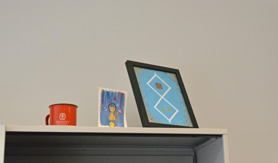 A painting of a kitten and of a puzzle inspired by the video game Witness on Hebbs shelf.