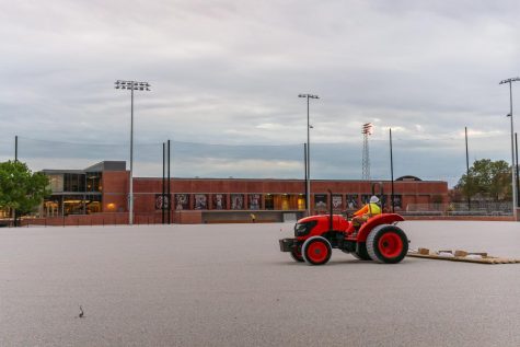 Construction crews lay a flat bed of concrete as they work to replace the recognizable baseball field on Lower Campus.