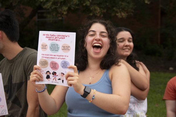 Student holds up paper for Trinity Tigerthon at Student Involvement Fair