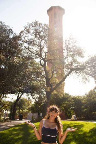 Freshman Trinity Rosas poses for picture in front of the Trinity Tower