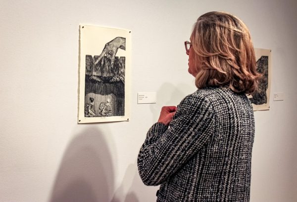 Kate Ritson, chair of the Art and Art History departments, admiring artwork by Jaida Johnson