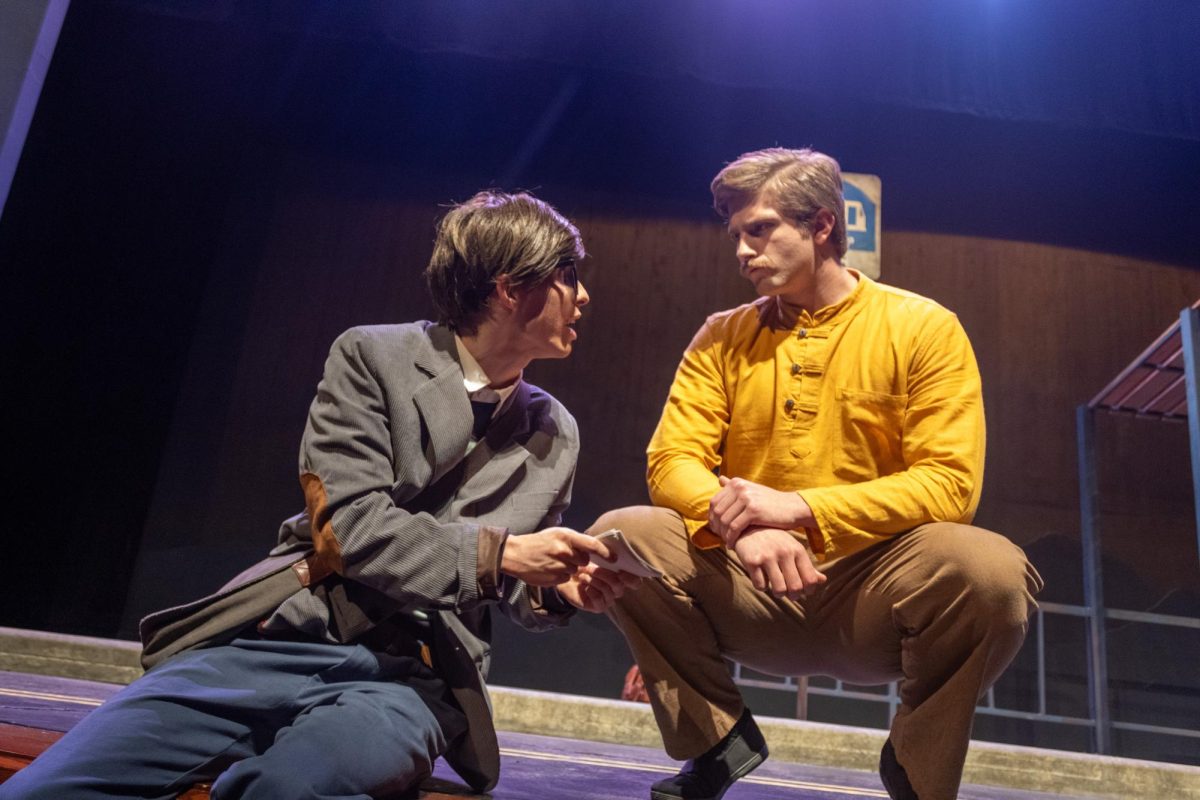 Neil Dobbs (left) looks up from his seat to speak with Zach Dycus (right) in the Stieren Theatre on Feb. 19.