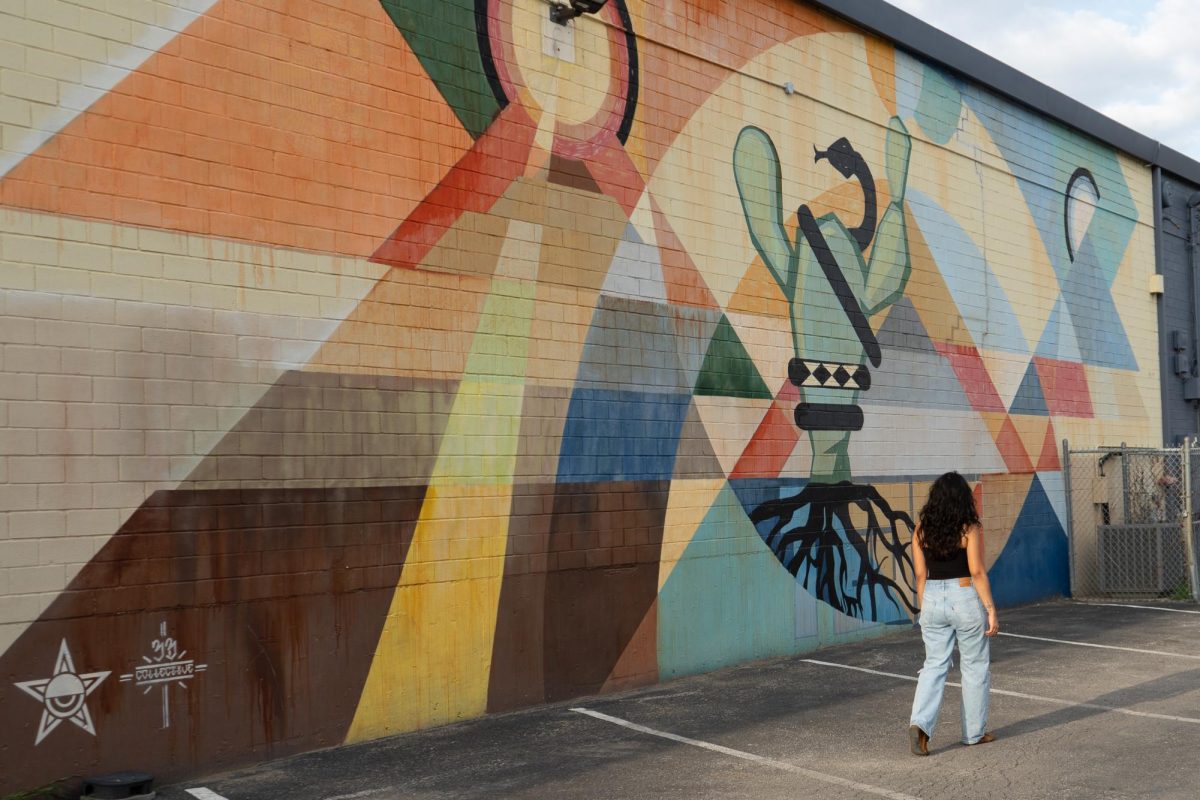 Passerby walks along "Tlatolli Itlaqual" (A Word is His Meal) by Oscar Mallagenes.